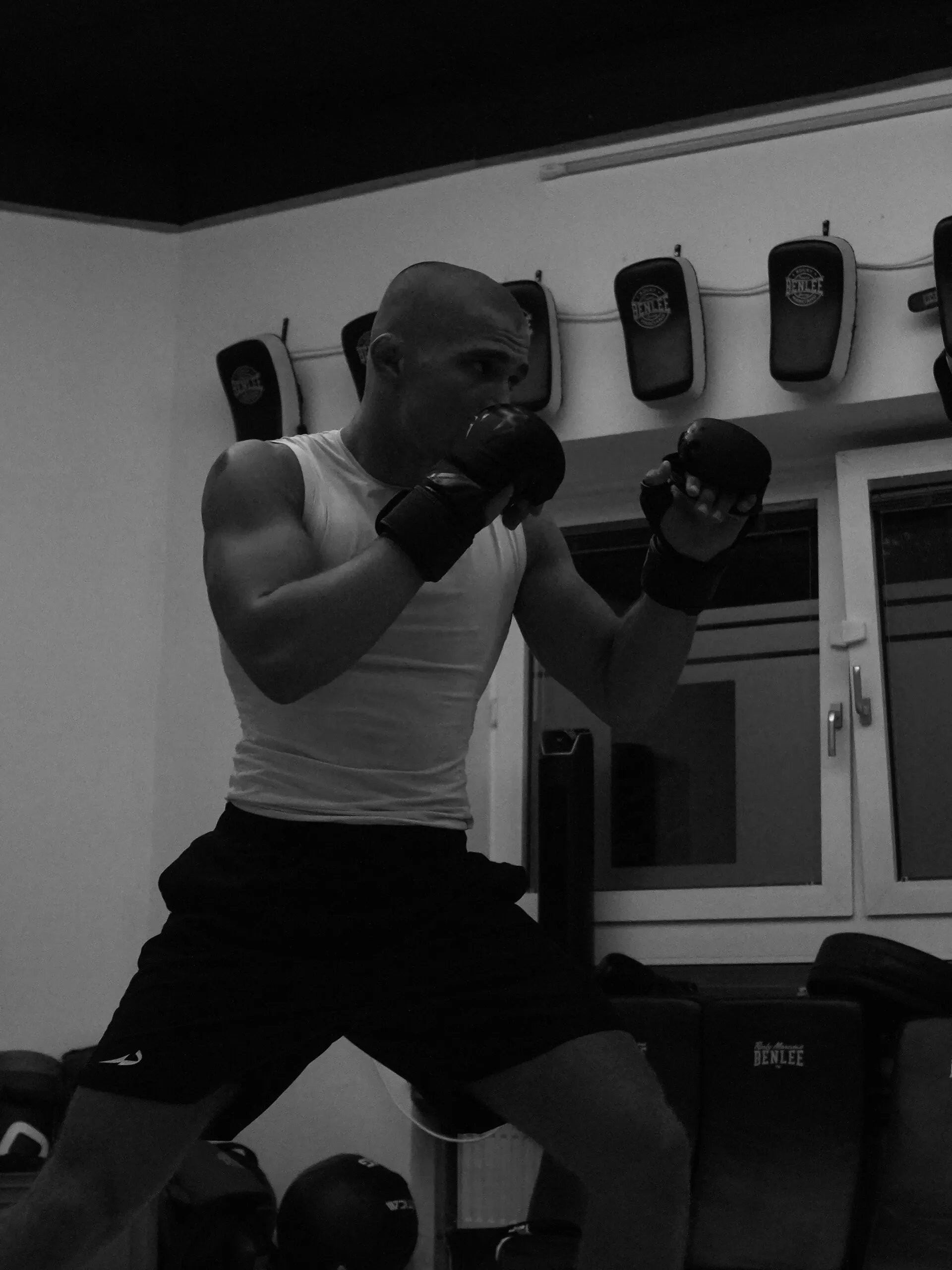 Moritz Barth in Kampfstellung mit MMA-Handschuhen im Gym, Schwarz-Weiß-Aufnahme aus dem Training.